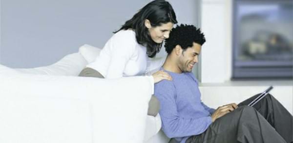 a man and a woman on a sofa with a tablet